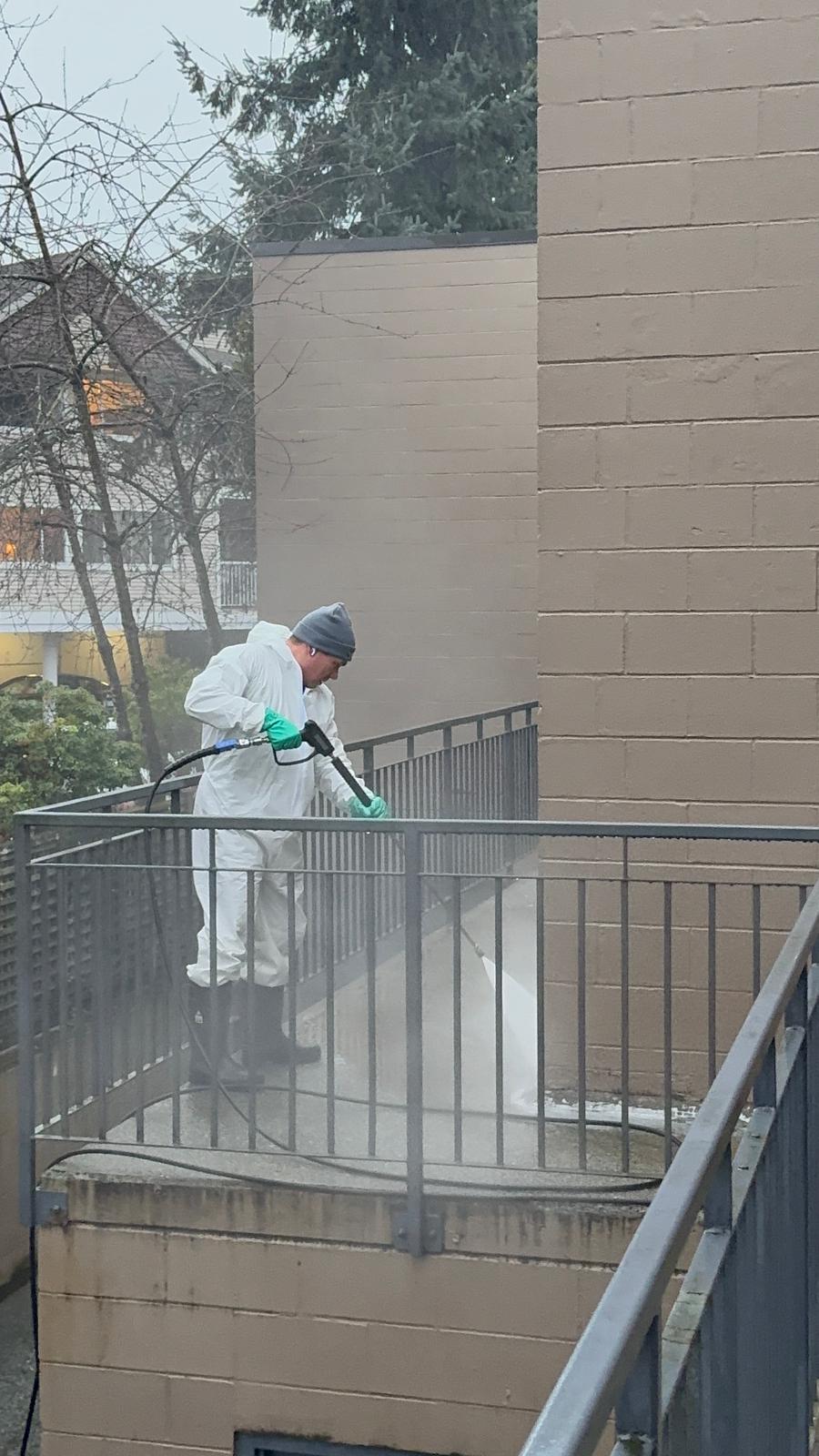 Worker pressure washing a driveway on the North Shore